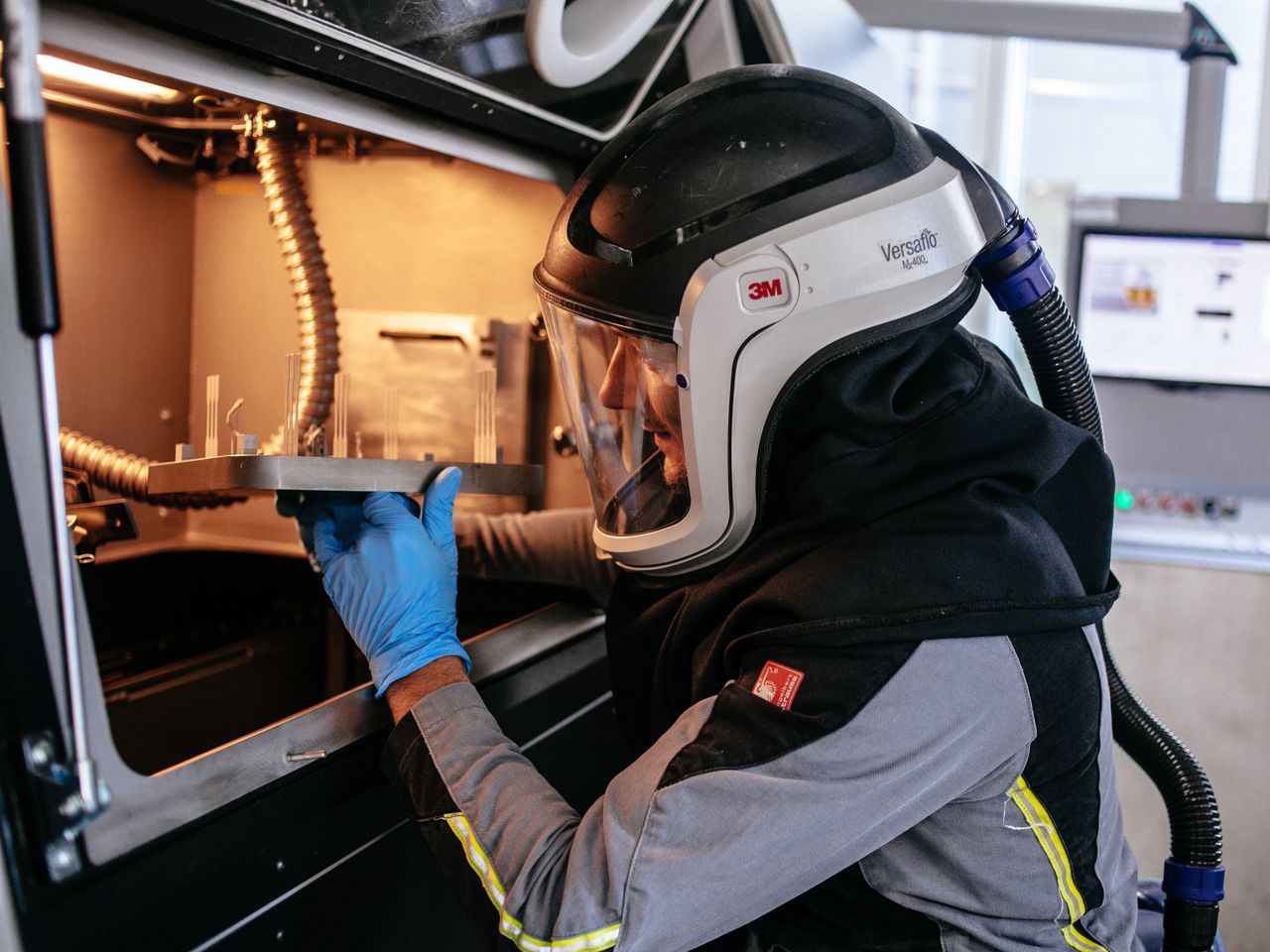 Employee removes a printed metal part from the metal 3D printer